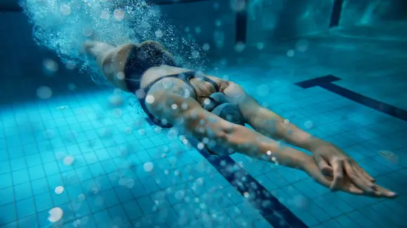 A woman diving into a swimming pool.