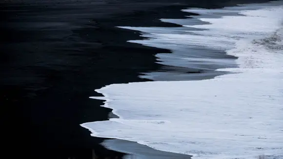  Reynisfjara black sand beach seen from Kirkjufjara in Vik, Iceland.