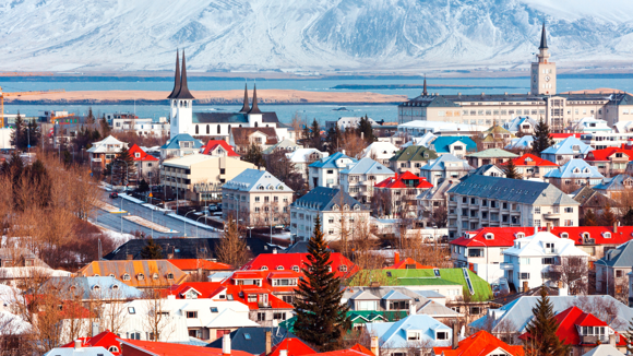 Reykjavík cityscape with colourful buildings and snowy mountains in the background.