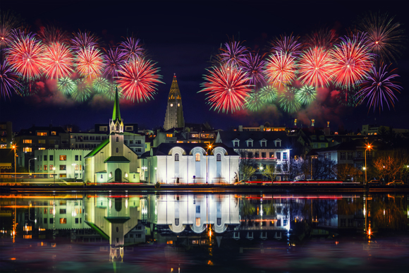 Colourful display of fireworks in the Reykjavík night sky during New Year’s celebration.