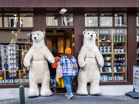 A tourist walking into a Reykjavík gift shop flanked by polar bears.