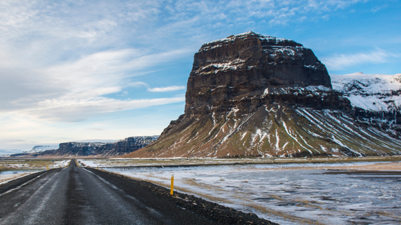 The Ring Road driving past the iconic Lómagnúpur mountain landmark with snow.