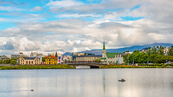 Colourful buildings of downtown Reykjavik with Lake Tjörnin in the foreground.