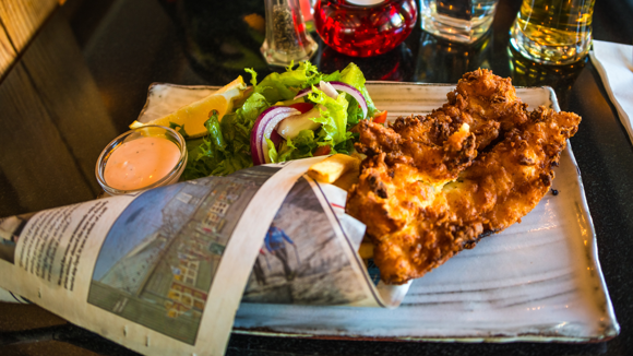Icelandic fish and chips served in a sheet newspaper on a plate