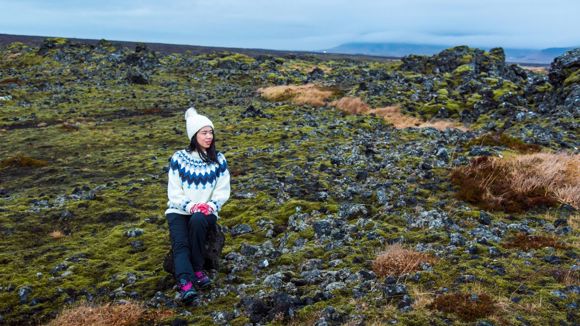 A female solo traveller in Iceland exploring lava fields on the Golden Circle route.