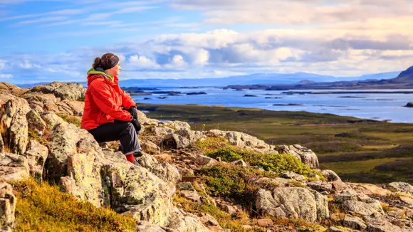 A hiker admiring the view from Helgafell Mountain in Iceland.