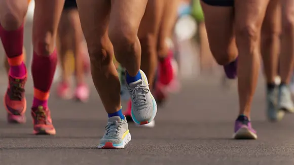 Close-up shot of runners with colourful running shoes.