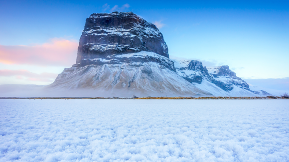 Snow and ice close up with the Lómagnúpur mountain dusted with snow